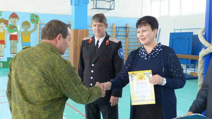 Начальник Районного управления образованием Н.А. Менжулова вручает грамоту  руководителю команды В.П. Вереневу